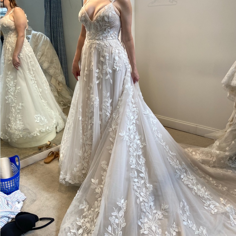 A beautiful never altered or worn wedding dress and color is ivory! Size 14